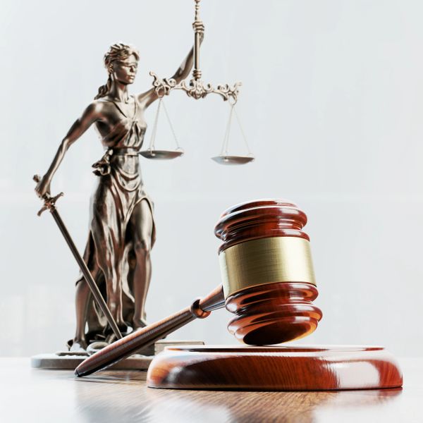 Lady Justice statue beside a gavel